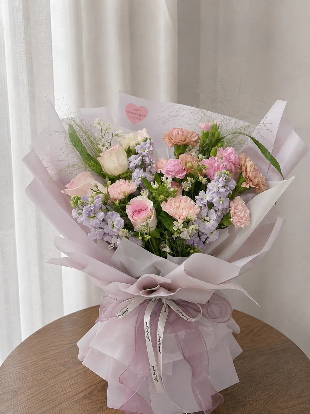 A bouquet of carnations and roses, hand-tied by Apple